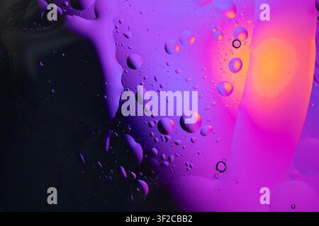 Olio e acqua che creano uno sfondo astratto con fluido fluente colorato e bolle fluttuanti Foto Stock