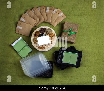 Diversi sacchetti di semi in carta kraft disposti a ventaglio contengono una varietà di semi tra cui girasole, piselli, senape e coriandolo. I microverdi crescono Foto Stock