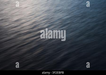 Immagine astratta che cattura il movimento sottile dell'acqua nelle isole Lofoten durante l'inverno. Le linee morbide e sfocate creano un effetto tranquillo e calmante Foto Stock