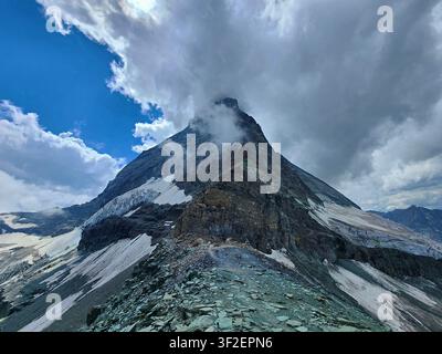 Vista del Monte Matterhorn con il suo iconico picco roccioso parzialmente oscurato dalle nuvole e pendici coperte di neve a Zermatt, Vallese, Svizzera. Foto Stock
