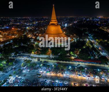Vista aerea ampia e panoramica di Chedi e mercato notturno con luci della città brillanti a Nakhon Pathom, Thailandia Foto Stock