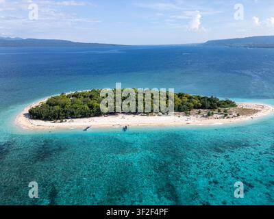 Ampia vista aerea con drone di un'isola tropicale con acqua turchese cristallina, spiagge di sabbia bianca e alberi tropicali. Isola di Tabuhan nella Giava orientale Foto Stock