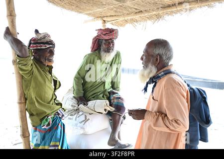 Distretto di Gaibandha, Divisione di Rangpur, Bangladesh – 15 febbraio 2026: Vista di tre uomini anziani con la barba in abiti tradizionali che conversano sotto un Foto Stock