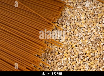 Texture macro di spaghetti integrali marroni crudi, motivo di spaghetti secchi, banner di lunghe gnocche di grano, primo piano di pasta maccheroni italiana cruda Foto Stock