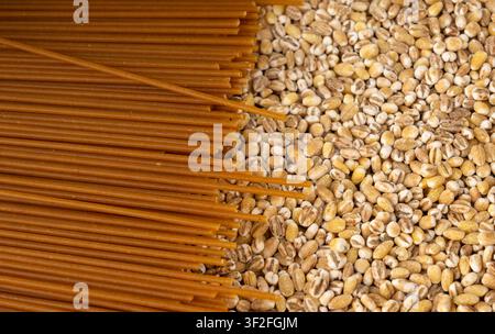 Texture macro di spaghetti integrali marroni crudi, motivo di spaghetti secchi, banner di lunghe gnocche di grano, primo piano di pasta maccheroni italiana cruda Foto Stock