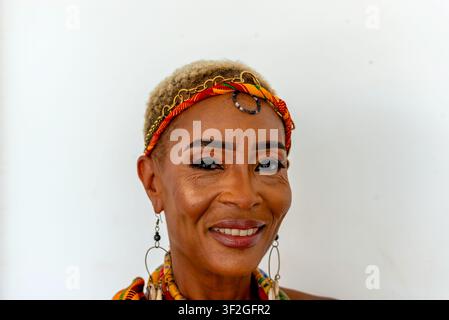 Ritratto di una donna Krobo sorridente con copricapo in kente, Odumase Krobo, Ghana Foto Stock