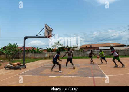 Giovani uomini che giocano a basket su un campo all'aperto, Odumase Krobo, Ghana Foto Stock