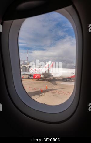 Bucaramanga, Colombia – 30 maggio 2026: vista dal finestrino di un passeggero dell’aereo che mostra un jet commerciale al gate di imbarco sulla pista, pronto per la partenza Foto Stock
