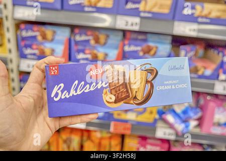 Crema di nocciola & Choc nuovo tipo di biscotto, una mano che mostra biscotti Bahlsen Cream & Choc con nocciole, sullo scaffale del supermercato, biscotti Bahlsen Foto Stock