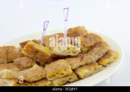Un piatto splendidamente disposto di soffici cialde alle uova mette in mostra una deliziosa prelibatezza culinaria. Uova sode affiorano dal centro del dorato Foto Stock