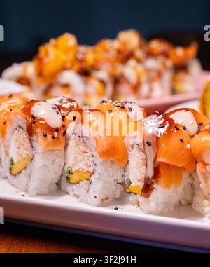 Rotoli di sushi al salmone su piatto bianco Foto Stock