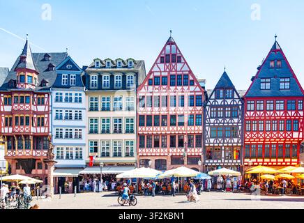 Francoforte, Germania - 15 maggio 2026: Case storiche a graticcio ornate su Piazza Roemerberg con terrazze di caffè all'aperto in una giornata di sole Foto Stock