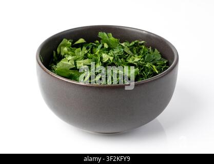 Prese di prezzemolo fresco tritate e aneto in ciotola isolata. Foglie di coriandolo affettate, erbe di giardino crude, crescione, pezzi di coriandolo su sfondo bianco Foto Stock