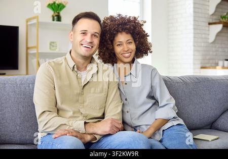 Ritratto felice che si rilassa insieme su un comodo divano a casa, sorridendo Foto Stock