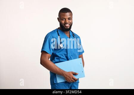 Giovane medico africano amichevole che tiene tabella medica Foto Stock