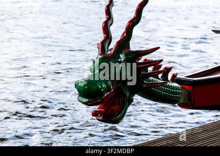 Primo piano dettagliato di una figura di prua a forma di testa di drago intagliata verde e rossa sull'ancora di una tradizionale barca drago Foto Stock