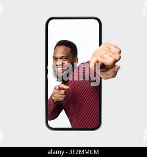 Uomo afroamericano felice che indica la fotocamera e sorride, concetto di perdita di peso Foto Stock