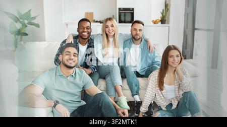 Gruppo di giovani amici multietnici che sorridono e si rilassano insieme a casa, concetto di stile di vita Foto Stock