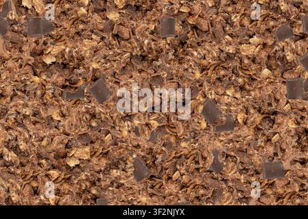 Motivo a forma di mucchio di granola al cioccolato, colazione muesli al cacao, sfondo di cereali croccanti, muesli di avena con semi e cereali, granola al cioccolato Foto Stock