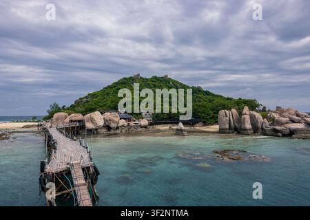 Molo di legno e sentiero pedonale sulla costa rocciosa dell'isola di Koh Nang Yuan con acque turchesi, Thailandia Foto Stock