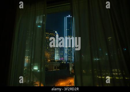Panorama notturno della skyline di Kuala Lumpur visto attraverso le tende dall'hotel Impiana. Foto Stock
