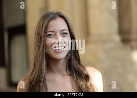 Giovane donna felice con lunghi capelli che sorride all'aperto Foto Stock