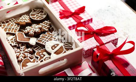 Biscotti di zenzero in un vassoio di legno con regali di Natale incartati Foto Stock