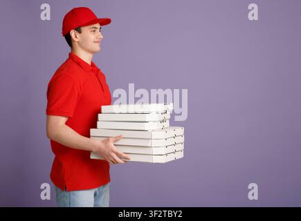 Lavoro popolare. Corriere sorridente in uniforme rossa che consegna la pizza Foto Stock