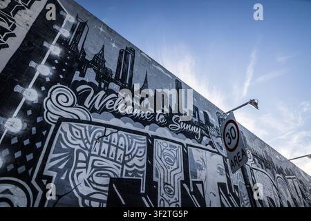 Affresco di una skyline urbana con il testo "Benvenuti a Sunny" e graffiti a Fitzroy, Melbourne, Australia Foto Stock