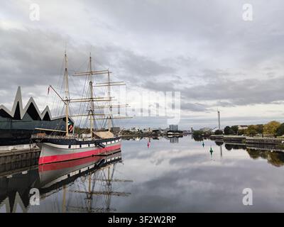 L'iconico Riverside Museum di Glasgow con la storica nave a vela Glenlee in una giornata nuvolosa Foto Stock
