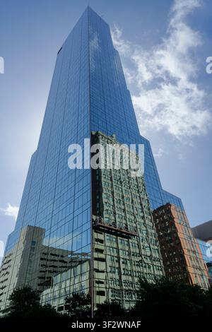 777 Main a Fort Worth, Texas, che riflette più parcheggi e hotel. I lavavetri pendono precariamente pulendo le finestre dell'edificio di vetro Foto Stock