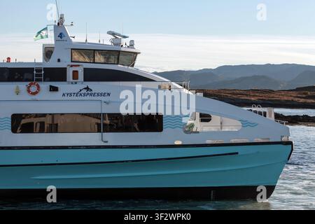 Sandstad, Norvegia – 17 ottobre 2016: Il traghetto passeggeri Kystekspressen scivola lungo acque costiere calme con uno scafo catamarano elegante, grandi finestre e vi Foto Stock