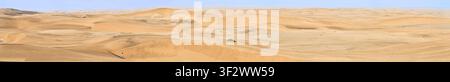 Un panorama massiccio ad alta risoluzione delle infinite dune di sabbia nel deserto del Namib, con una persona in giacca arancione che cammina in lontananza. Foto Stock