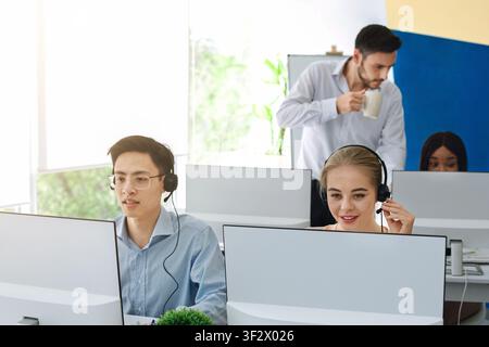 Diversi operatori del servizio clienti nelle cuffie che lavorano nel call center Foto Stock
