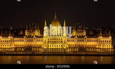 Vista aerea del Parlamento ungherese illuminato di notte lungo il Danubio a Budapest, Ungheria. Foto Stock
