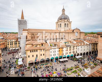 Il centro storico di Mantova visto dall'alto, che mostra la Basilica di Sant'Andrea e la vivace Piazza delle Erbe piena di bancarelle del mercato e m Foto Stock