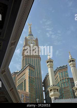 Vista ad angolo basso della Torre dell'Orologio della Mecca e dei Minareti di Masjid Al-Haram Un drammatico scatto ad angolo basso che incornicia l'iconica orologio della Mecca Foto Stock