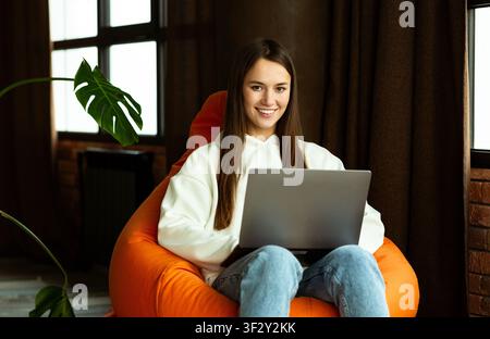 Donna freelance lavora in borsa sedia a casa Foto Stock