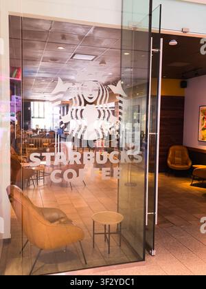 DALLAS, TX, USA - 11 LUGLIO 2026: Una vista invitante di un caffè Starbucks con una porta in vetro trasparente che mostra il logo iconico. All'interno, il negozio Foto Stock