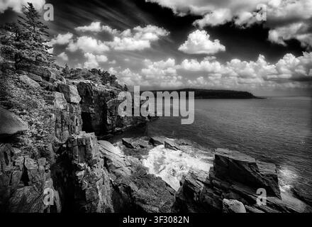 Questa fotografia artistica in bianco e nero mette in mostra la drammatica costa di granito del Parco nazionale di Acadia in una mattina di primavera. Le onde si infrangono contro Roc Foto Stock