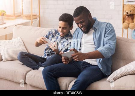 Happy Black Padre E Son Giocare Insieme Ai Videogiochi Sullo Smartphone Foto Stock