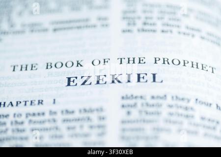 Un macroscatto della pagina del titolo del Libro di Ezechiele in una Sacra Bibbia, con tipografia nera nitida e profondità di campo ridotta su un bianco pulito Foto Stock