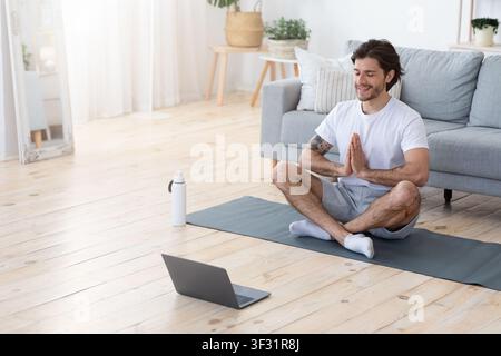 Uomo attento e bello meditating da solo a casa Foto Stock
