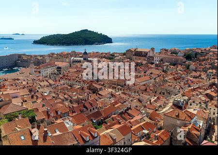 Esplora i vivaci tetti rossi della città vecchia di Dubrovniks contro il mare cristallino. Foto Stock