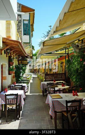 Chania, Grecia - 27 maggio 2014: Ristorante con posti a sedere all'aperto in un vicolo stretto nella parte vecchia della città di Creta Foto Stock