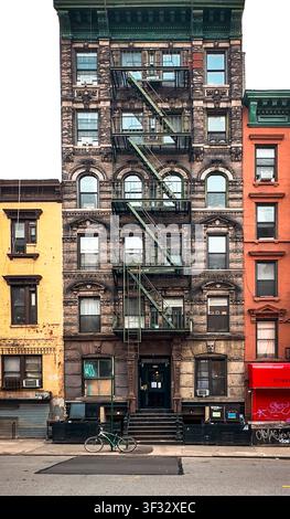 New York City, USA, 30 aprile 2024, un edificio in mattoni con una scala antincendio esterna in metallo situata su Madison Street Foto Stock