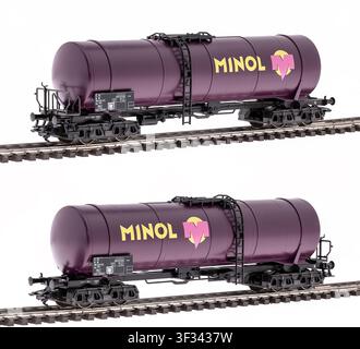 Modello dettagliato in scala HO di un carro cisterna viola Minol, mostrato da entrambi i lati su una linea ferroviaria, isolato su sfondo bianco. Foto Stock