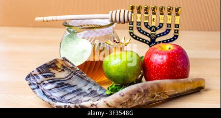Simboli di Rosh Hashanah tra cui shofar, vasetto di miele, mele e melograno Foto Stock