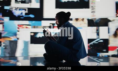 Giovane in solitudine affetto da ansia e manipolazione, evidenziando la sofferenza dovuta all'abuso ossessivo dei social network. Il sovraccarico di informazioni derivante dall'interazione costante causa danni. Fotocamera B. Foto Stock