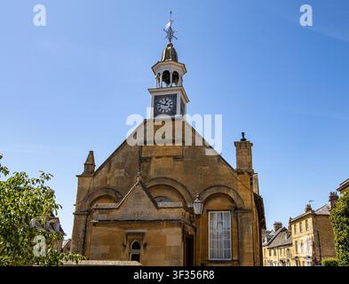 Historico municipio in arenaria con torre dell'orologio e cupola sotto un cielo azzurro limpido a Chipping Campden Foto Stock